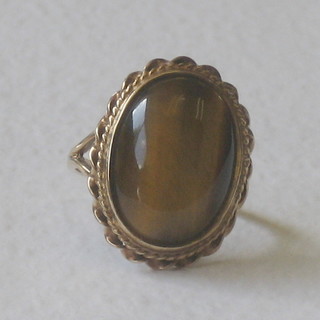 A 9ct gold dress ring set a cabouchon cut oval cut Tigers Eye