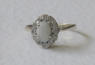 A lady's 9ct gold dress ring set an oval cut opal surrounded by diamonds