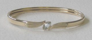 A 9ct gold bangle set an oval cut aquamarine