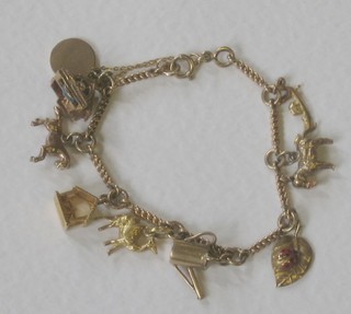 A gilt metal charm bracelet hung numerous charms