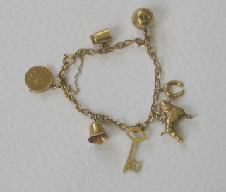 A gold curb link charm bracelet hung 7 various charms