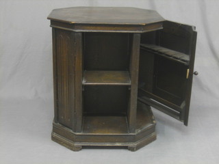 A 1930's octagonal carved oak drinks cabinet fitted shelves to the side, raised on a platform base 24"