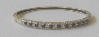 A gold hoop shaped bracelet set sapphires and diamonds