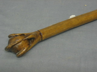 A carved wooden walking stick, the handle in the form of a claw clasping an egg
