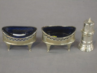 A pair of Victorian oval pierced silver salts with blue glass liners, raised on panel supports London 1894 and a silver pepperette
