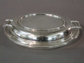 A pair of silver plated twin handled entree dishes and covers with bead work borders
