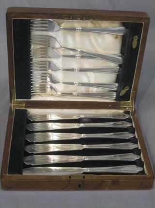A set of 6 silver plated fish knives and forks contained in an oak canteen box