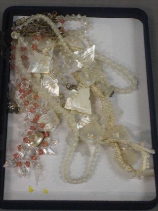 A string of mother of pearl beads and various other necklaces