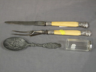 A Victorian steel carving knife and fork, a white metal embossed spoon and a cylindrical pin jar
