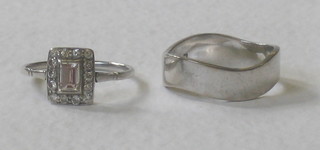 An 18ct gold wedding band and a white metal dress ring