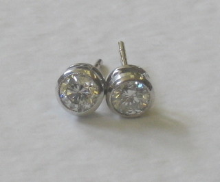 A pair of lady's solitaire diamond earrings, approx 0.65ct