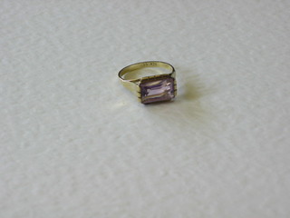 A gold dress ring set a rectangular cut amethyst