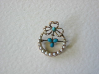 An Edwardian 9ct gold ribbon shaped brooch set demi-pearls and turquoise