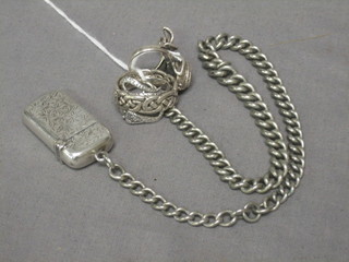 3 silver rings and a silver curb link watch chain hung a silver vesta case