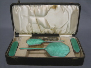 An Art Deco silver and green enamelled 4 piece dressing table set comprising pair of clothes brushes, hair brush and hand mirror, Birmingham 1933, cased