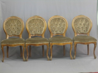 A set of 4 Continental bleached mahogany balloon back dining chairs with upholstered seats and backs, raised on French cabriole supports