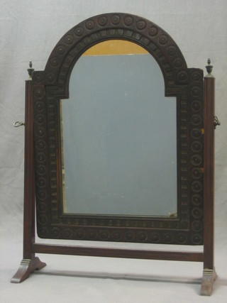 An arched plate dressing table mirror contained in a carved oak swing frame 18"