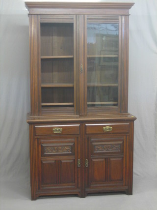 A Victorian mahogany bookcase on cabinet, the upper section with moulded cornice the interior fitted adjustable shelves enclosed by glazed panelled doors, the base fitted 2 drawers above a double cupboard enclosed by panelled doors 48"