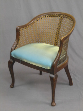 A beech framed tub back armchair with woven cane back, raised on cabriole supports