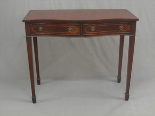 A Georgian style inlaid mahogany side table of serpentine outline, fitted 2 long drawers, raised on square tapering supports ending in spade feet 39"