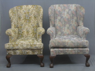 A pair of mahogany framed Georgian style winged armchairs, raised on cabriole claw and ball supports