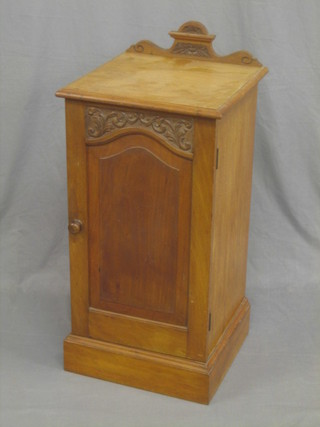 A Victorian carved walnut pot cupboard with raised back enclosed by a panelled door, raised on a platform base 16"