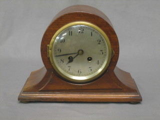 A striking mantel clock with silvered dial and Arabic numerals  contained in an arch shaped mahogany case