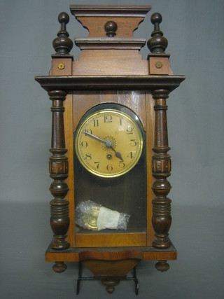A wall clock with paper dial and Arabic numerals contained in a walnut case
