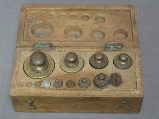 A wooden box containing a collection of various chemical weights by Jones Bros.