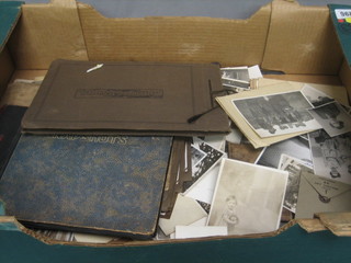 A box containing 3 old black and white photograph albums and a collection of various black and white photographs