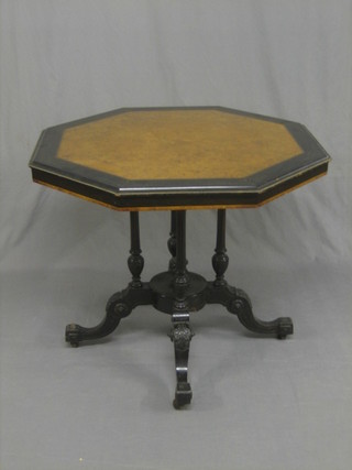 A Victorian octagonal Amboyna and ebonised centre table, raised on 4 turned columns ending in scrolled feet 32"