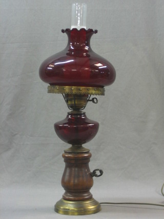 A reproduction Victorian red glass and turned beech table lamp in the form of an oil lamp 26"