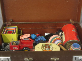 A small brown attache case containing a collection of various children's toys