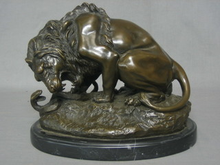 A modern bronze figure of a lion with cobra, raised on an oval marble base 12"