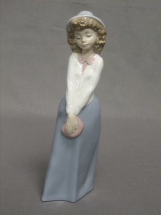 A Nao figure of a standing bonnetted girl with a bag, the base marked Nao 9"
