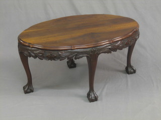 An oval Edwardian carved mahogany occasional table, raised on cabriole ball and claw supports 35"