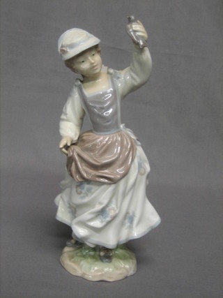 A Lladro figure in the form of a standing girl with bird, the base marked 1317 11"