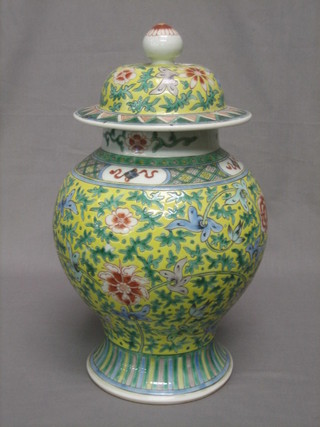 An Oriental yellow and green ground baluster shaped urn and cover 14"