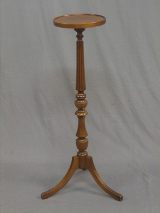 A Georgian style mahogany torchere raised on a turned and reeded column
