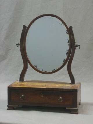 A 19th Century oval plate dressing table mirror contained in a mahogany swing frame, the base with star inlay, fitted a drawer and raised on ogee bracket feet 12"