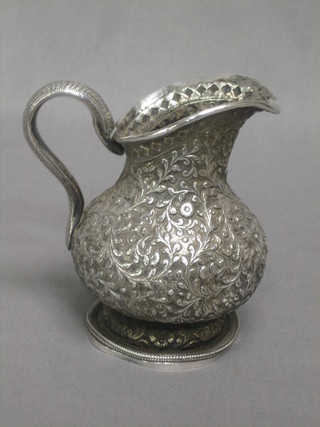 A circular embossed Eastern silver jug, raised on a spreading foot, 10 ozs