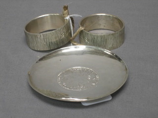A pair of modern silver napkin rings 4 ozs and a circular silver ashtray set a coin