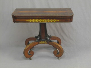 A William IV rosewood brass inlaid D shaped card table, raised on a chamfered column with scrolled supports 35"
