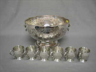 A circular embossed silver plated twin handled punch bowl together with 6 associated engraved silver plated punch cups by Garrard & Company