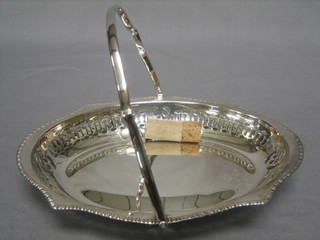 A pierced silver plated boat shaped cake basket with swing handle together with a bottle stopper
