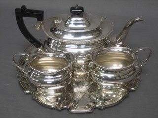 A Georgian style oval silver plated 3 piece tea service comprising teapot, sugar bowl and cream jug by Garrards together with an engraved salver with bracketed border