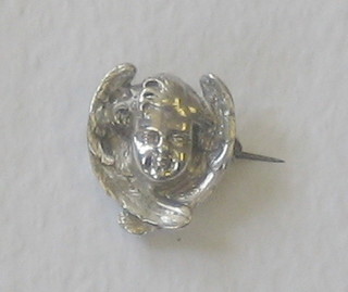 A cast silver brooch in the form of a cherub