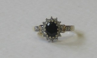 A 9ct gold dress ring set a sapphire supported by diamonds