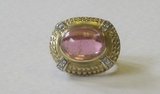 A 14ct gold dress ring set a cabouchon cut tourmaline supported by diamonds