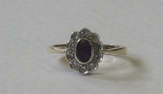 A gold dress ring set an oval cut amethyst supported by diamonds